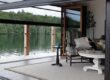 Cozy outdoor seating area overlooking a serene lake on a wooden deck.
