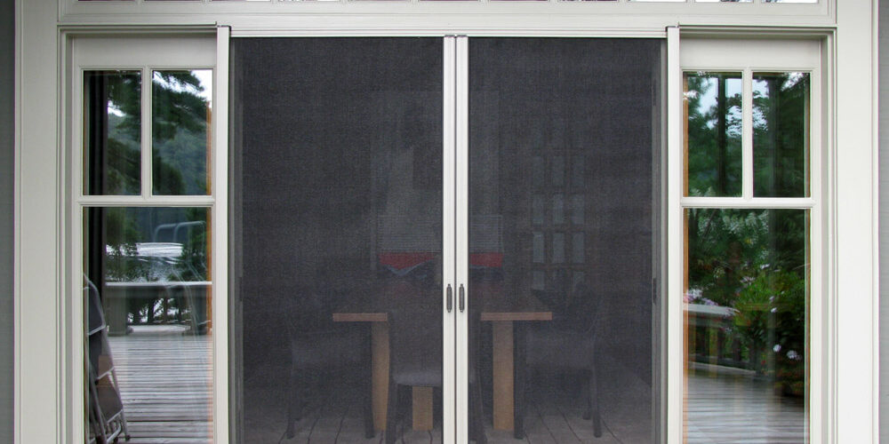 Sliding glass doors with mesh screens leading to a patio area.