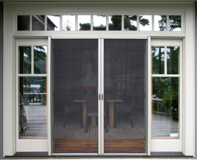 Sliding glass doors with mesh screens leading to a patio area.