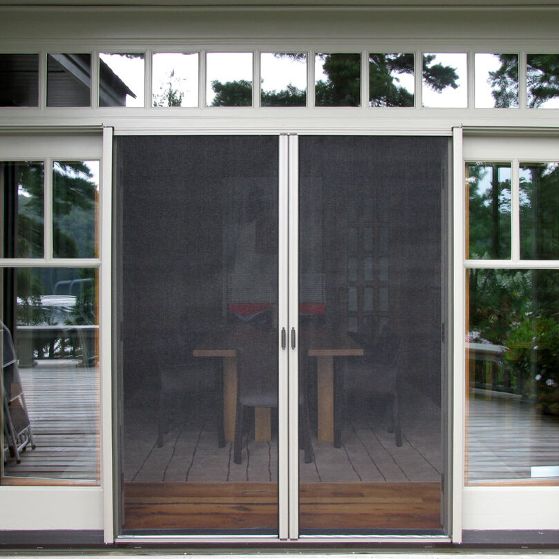 Sliding glass doors with mesh screens leading to a patio area.