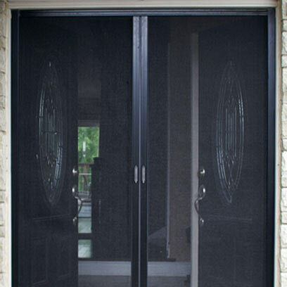 Black sliding mesh door with handles in a doorway.