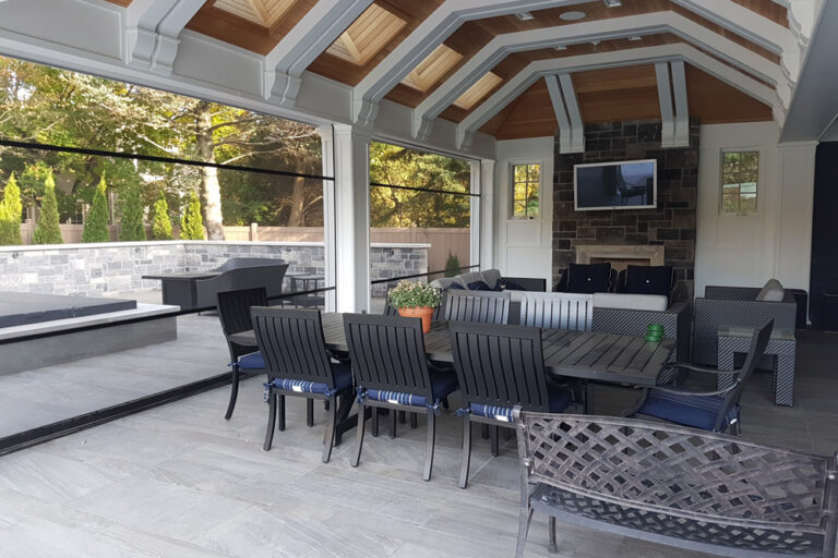 Cozy outdoor patio with dining and lounge seating under a wooden roof.