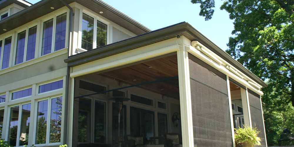 Modern house exterior with large windows and screened porch.