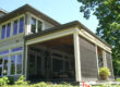 Modern house exterior with large windows and screened porch.
