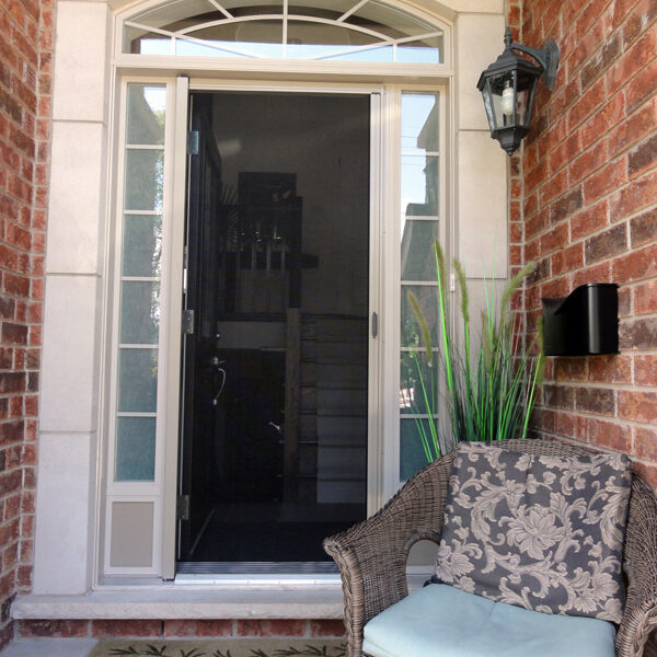 A modern front door with glass panels and a wicker chair on the porch.