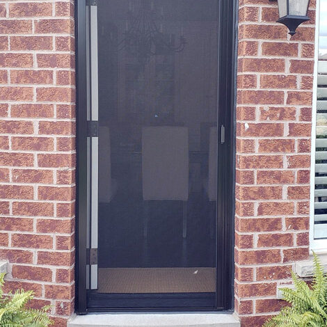 Black mesh screen door on a brick wall entrance.