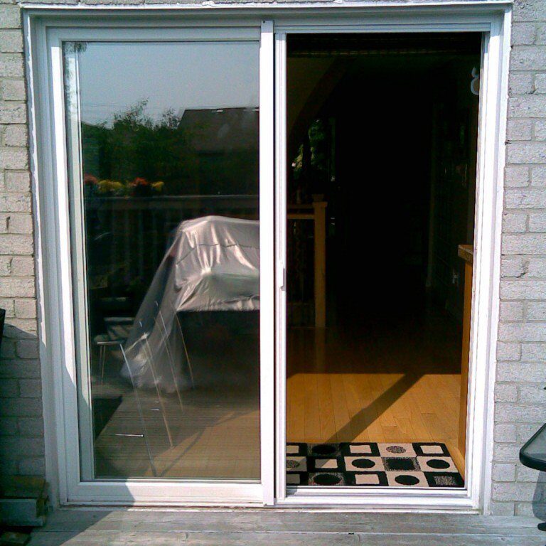Sliding glass door leading to an interior room with a patterned rug.