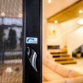 Close-up of a security camera sticker on a glass door handle.