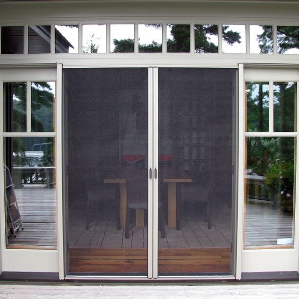 Modern sliding glass doors with mesh screens in a bright room.