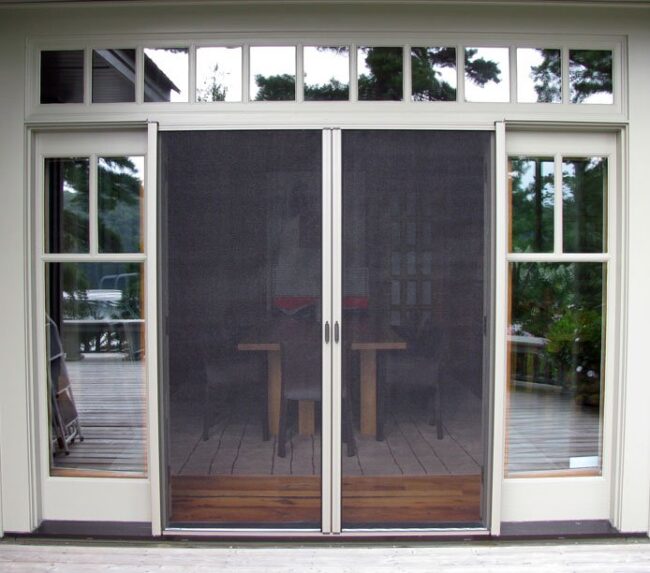 Modern sliding glass doors with mesh screens in a bright room.