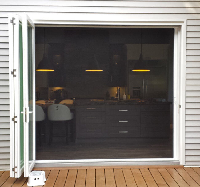 Retractable screen door partially open on a patio.