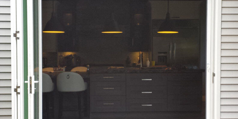 Retractable screen door partially open on a patio.