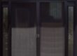 A closed double glass door with dark frames and mesh screens.