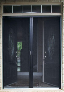 Black mesh screen door in a doorway with a view inside a house.